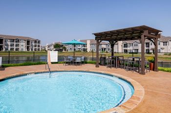 A swimming pool with a gazebo next to a resort style pool